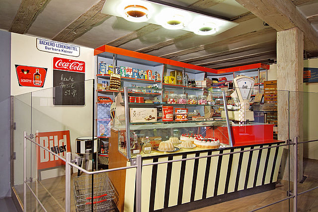 Ein alter Kaufladen mit Glastheke in der Backwaren und andere Lebensmittel ausgestellt werden.