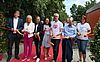 Vertreterinnen und Vertreter der Stadt Forchheim und Politik sowie die Leitungen der KiTa Sattlertor und Sattlertörchen durchschneiden das rot-gelbe Band mit den Farben der Stadt Forchheim zur Einweihung der neuen Kita.