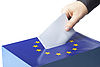 Wahlurne zur Europawahl mit Hand welche den Wahlzettel in die Urne wirft