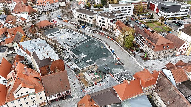 Eine Luftbildaufnahme zeigt eine Großbaustelle auf einem großen Platz in einer Stadt.