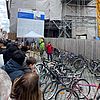 Auf einem öffentlichen Platz begutachten viele Menschen ausgestellte Fahrräder.