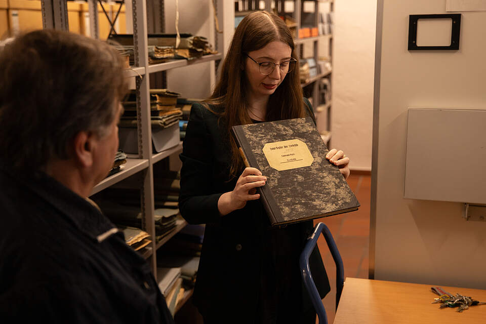 Stadtarchivarin Miriam Mulzer präsentiert einer Besucherin im Stadtarchiv Archivalien