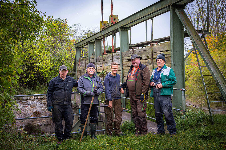 Personen vor großem Wehr