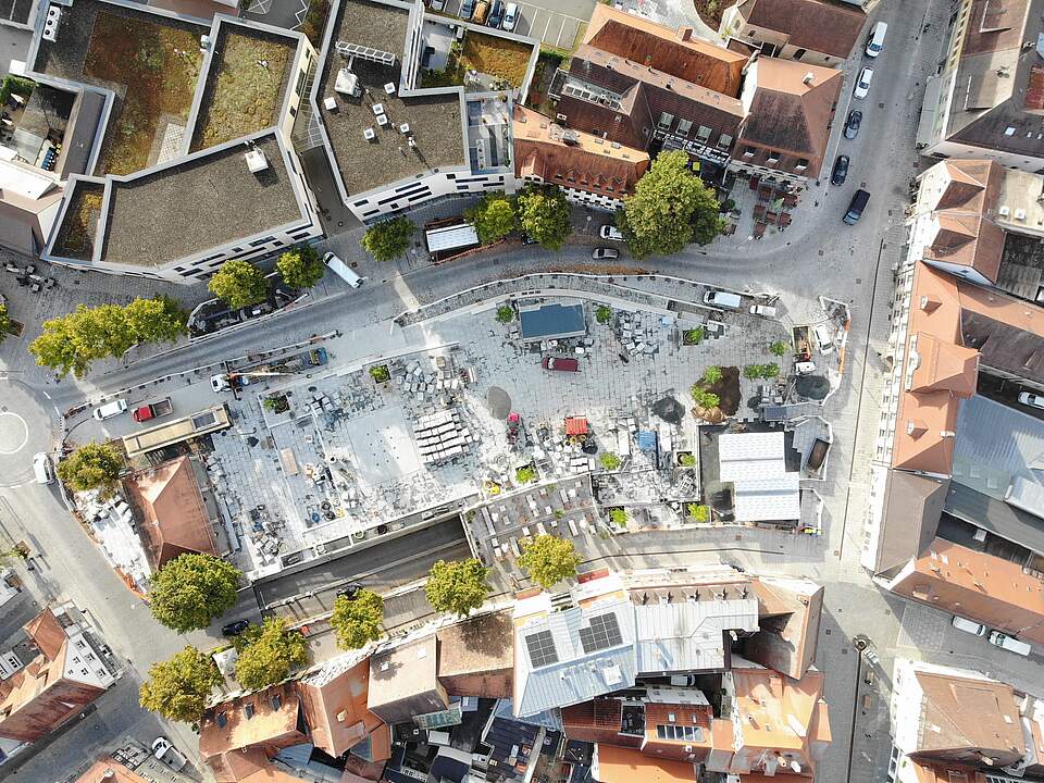 Luftaufnahme Paradeplatz Eine Luftbildaufnahme zeigt die Umbaumaßnahmen auf einem großen Stadtplatz mit Pflasterarbeiten, Baumaterial und neuen Bäumen.