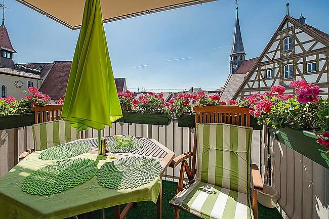 Zimmer des Kathrarinenspitals mit Stühlen, Tisch und Sonnenschirm