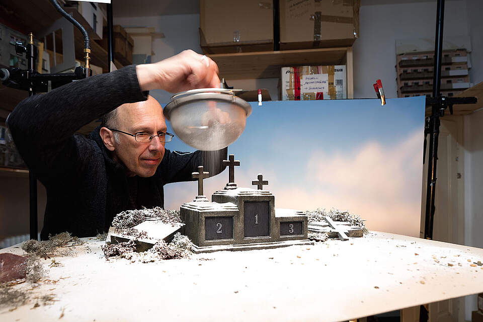 Künstler vor Modell mit Sieb und Kunstschnee