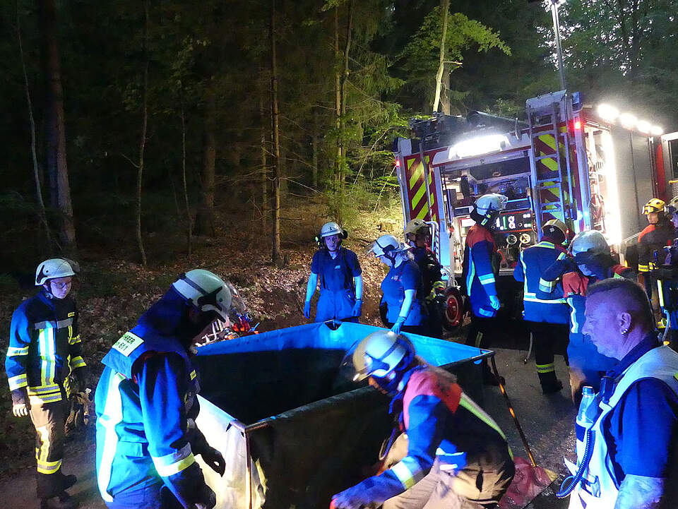 Aufbau eines Löschwasserbassins Ein Löschwasserbassin wird aufgebaut. Im Dunkeln nicht einfach aber jeder Handgriff sitzt. Die Umgebung im Wald ist ausgeleuchtet mit Strahlern.