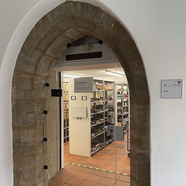 Eingangsbereich eines Archivraums mit gefüllten Regalen.