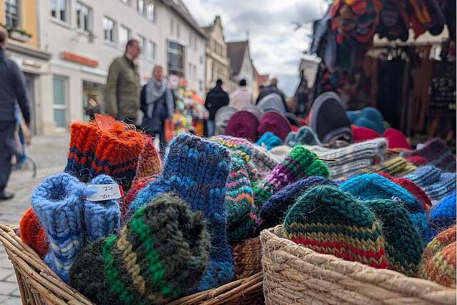 Bunte gehäkelte Socken aus Wolle, im Korb und in der Innenstadt 