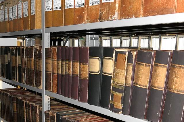 Bänder und Ordner in Schwerlastregalen eines Archivs.