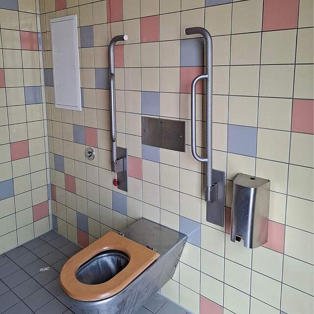 Der nach Vandalismus sanierte Innenbereich des barrierefreien WCs am Forchheimer Bahnhof zeit die Toilettenanlage mit seitlichen, hochgeklappten Stützen.