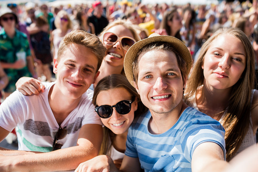 Fünf Teenager beim Festival machen ein Selfie.