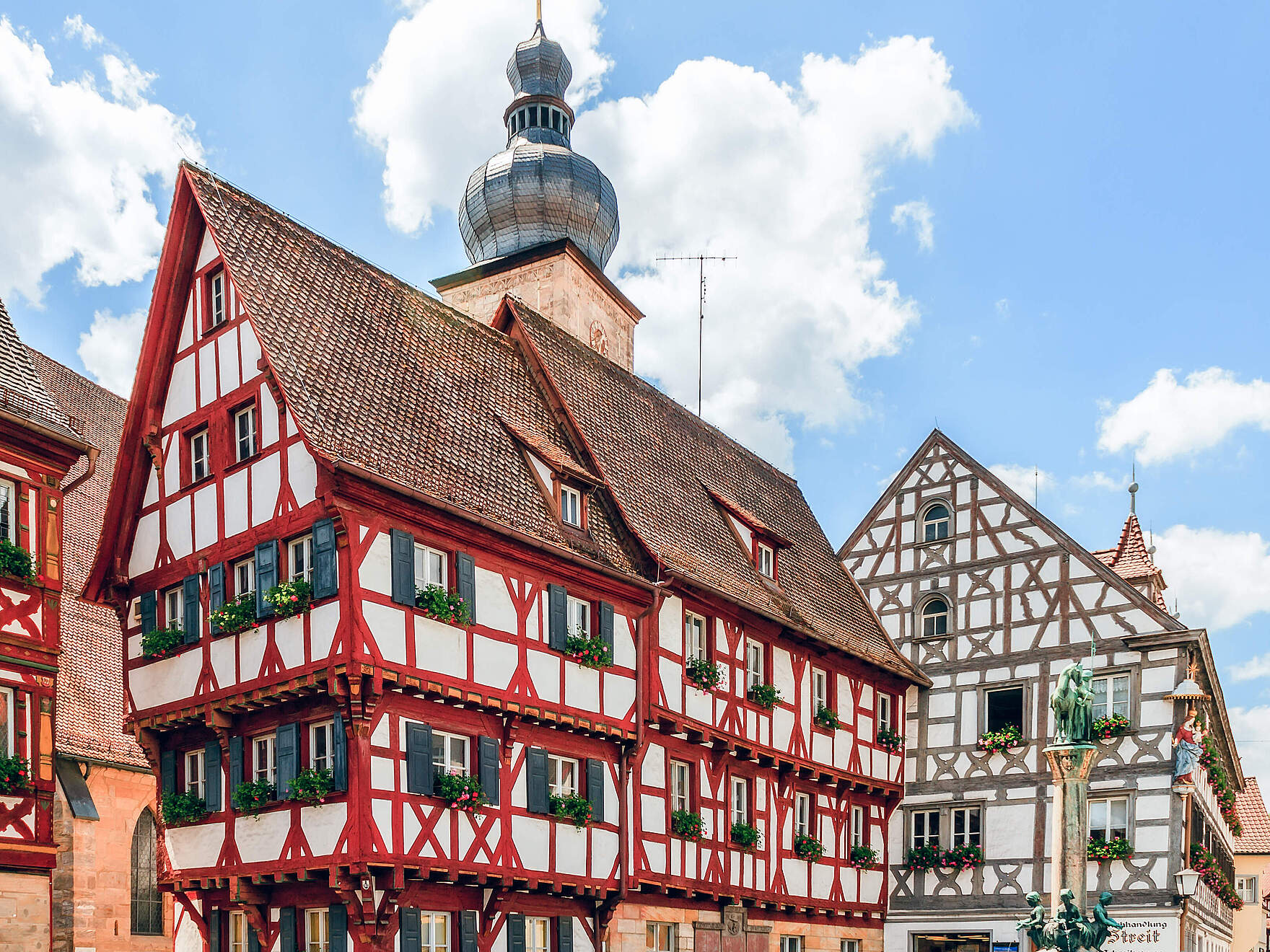 Malerischer Fachwerkbau mit kleinem Glockenturm. Bewölkter Himmel.