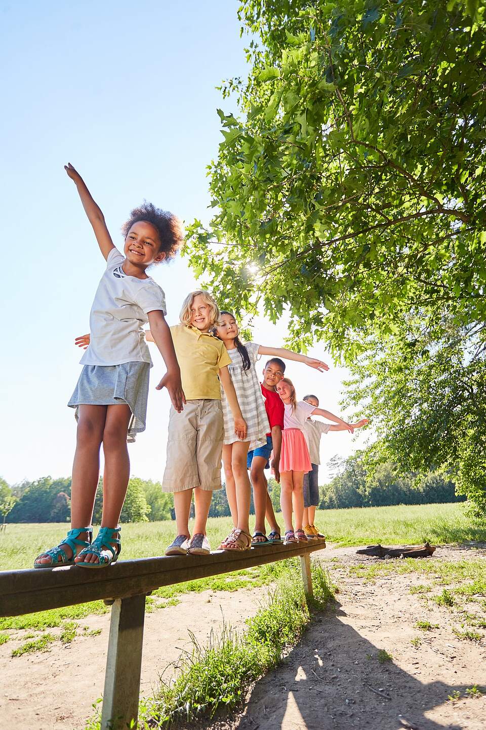 Kinder auf Balancierstange im Sommer