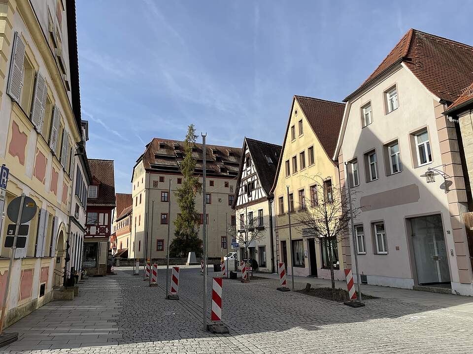 Straßensperrung wegen Weihnachtsmarkt 2025 Ein Straßenzug in der Forchheimer Innnestadt mit der Kaiserpfalz am Ende der Sattlertorstraße mit Barken und Stangen für die Installation der Weihnachtsbeleuchtung.