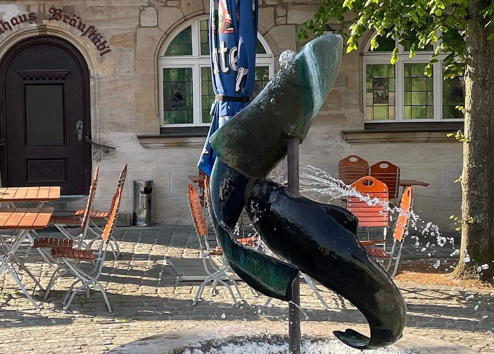 Nahaufnahme des Forellenbrunnens mit zwei sich in einer Spirale gewundenen Forellen.