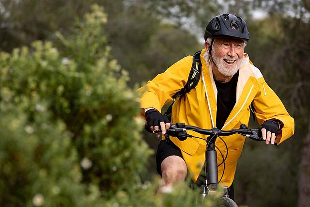 Fahrradfahrer mit gelber Jacke und Helm