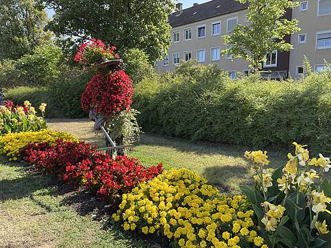 Blumenschmuck in der Bamberger Straße Buntes Sommerblumenbeet mit einer bepflanzten Figur, die einen Gärtner darstellen soll.
