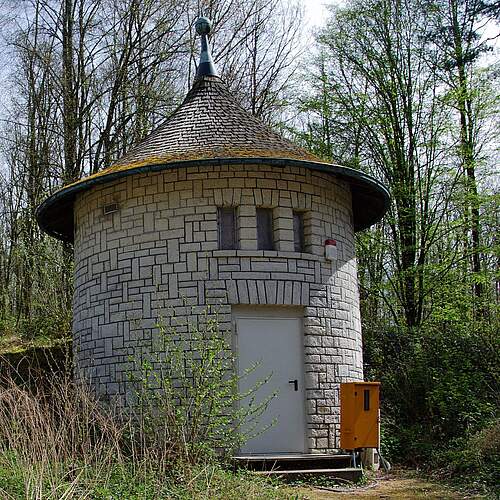 Alter, runder Wasserhochbehälter im Kellerwald umgeben von Bäumen