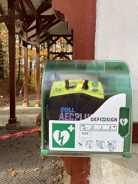 Ein Schutzgehäuse mit einem Defibrillator (AED) hängt an einem Gebäude öffentlich zugänglich im Kellerwald.