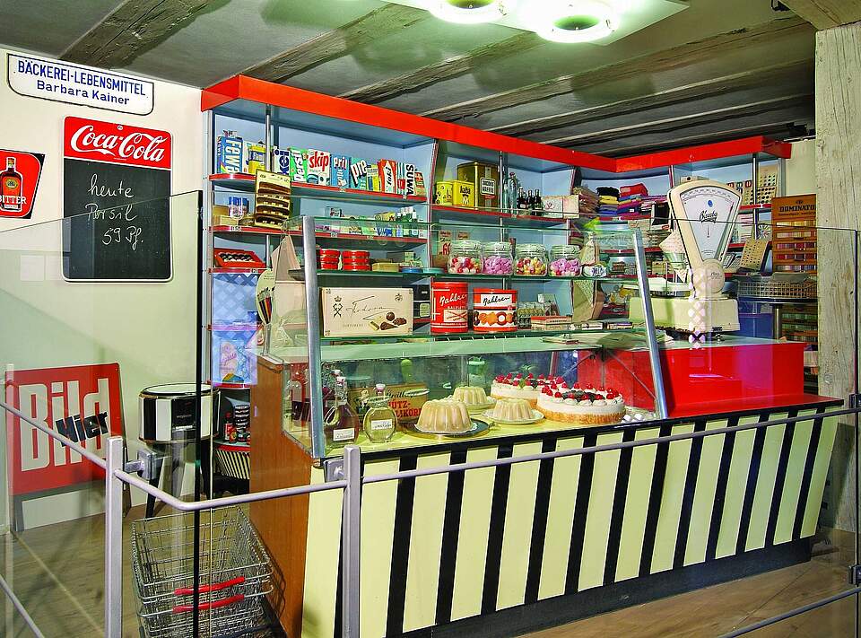 Historischer Kauflanden aus den 50er Jahren im Forchheimer Stadtmuseum. Ein historischer Kaufladen im Stil der 50er Jahre mit Kuchen, Likörflaschen und Keksdosen.