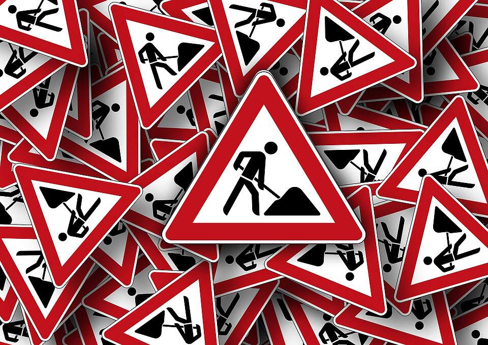 Baustellen Warnschilder Mehrere Baustellen-Warnschilder liegen übereinander.