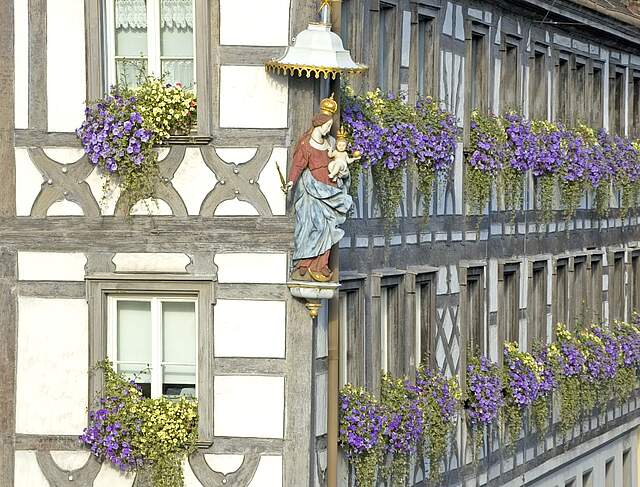 Außenansicht mit Fachwerkfassade eines Forchheimer Amtsgebäudes mit der Heiligenfigur Maria.