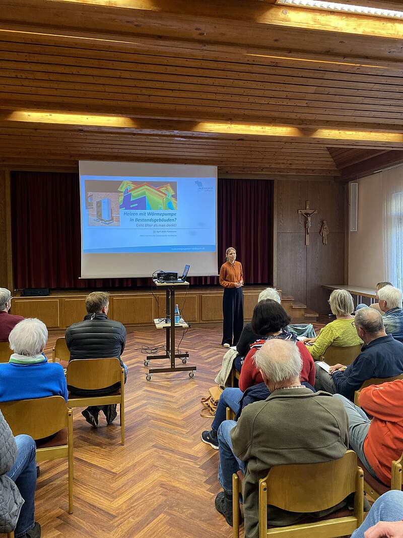 Großer Raum mit Leinwand und einem Vortrag über Wärmepumpen