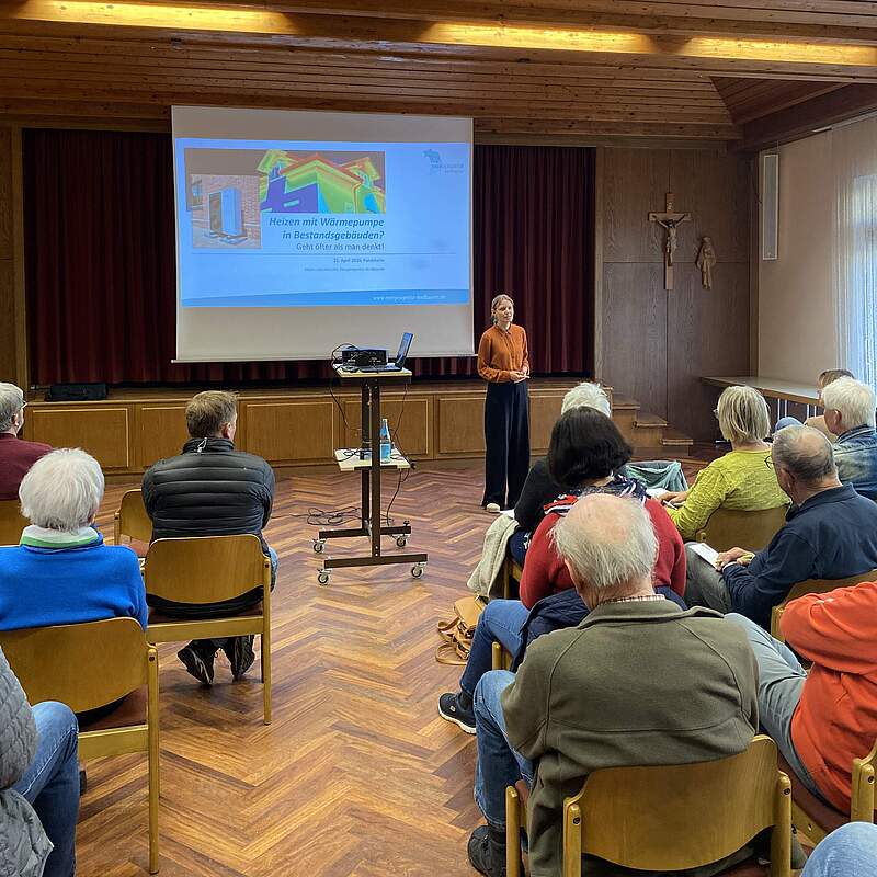 Großer Raum mit Leinwand und einem Vortrag über Wärmepumpen