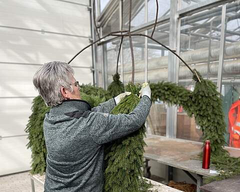 Eine Osterkrone für den Brunnenschmuck wird aufgebunden Eine Mitarbeiterin des Gartenamts bindet für eine Brunnen-Osterkrone das Grundgerüst