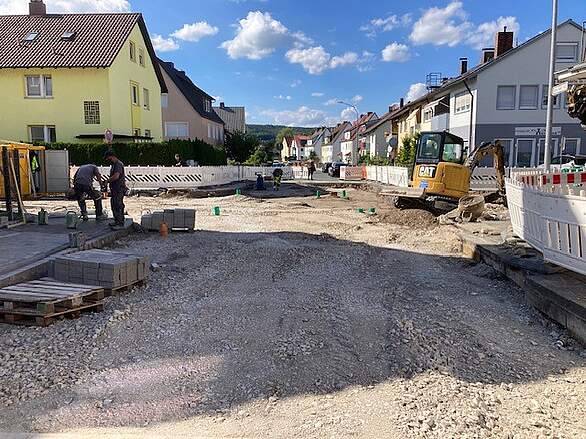 Neugestaltung Bammersdorfer Straße - Bauarbeiten an der Kreuzung Von-Ketteler-Straße Bauarbeiten zur Straßenneugestaltung mit Baufahrzeugen, Container und Absperrbarken an einer Straßenbaustelle im Kreuzungsbereich Bammersdorfer Straße und Von-Ketteler-Straße.