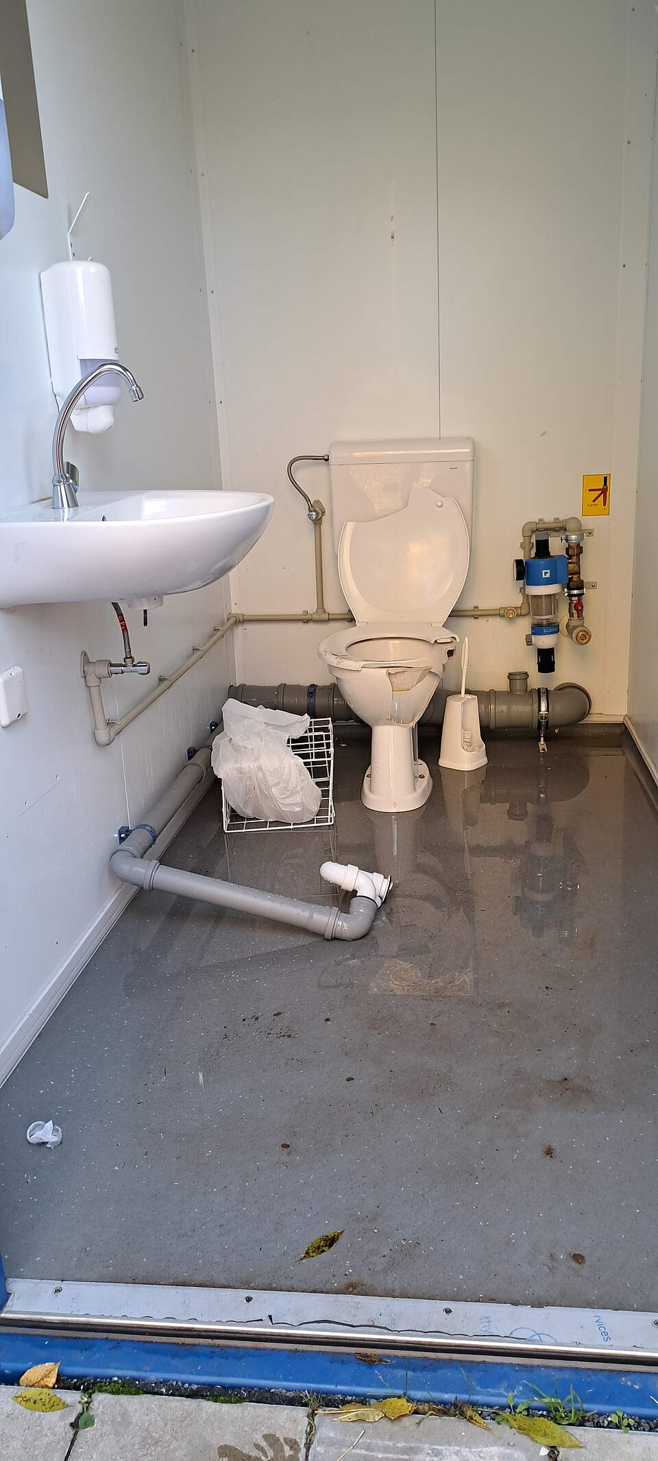 Vandalismus auf der Sportinsel Eine zerstörte Toilettenanlage in einem Container. Bruchstücke der Toilettenschlüssel und ein abgerissenes Wasserrohr liegen über den Boden verteilt.