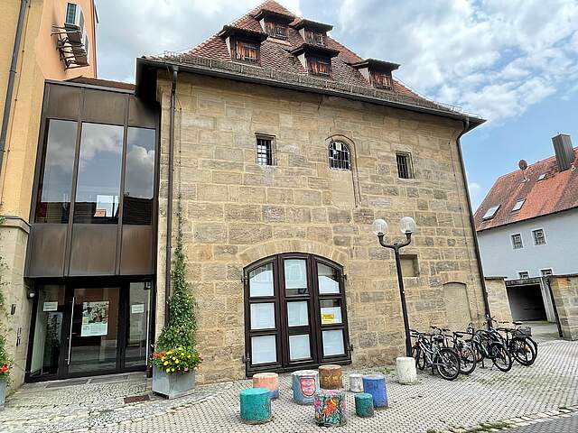 Frontalansicht der Fraunkscheune, die das Forchheimer Stadtarchiv beherbergt. Der massive Sandsteinbau erstreckt sich über zwei Vollgeschosse, sowie zwei weiteren Dachgeschossen.dsteinen
