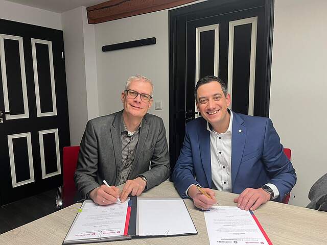 Zwei Herren bei einer Vertragsunterzeichnung.