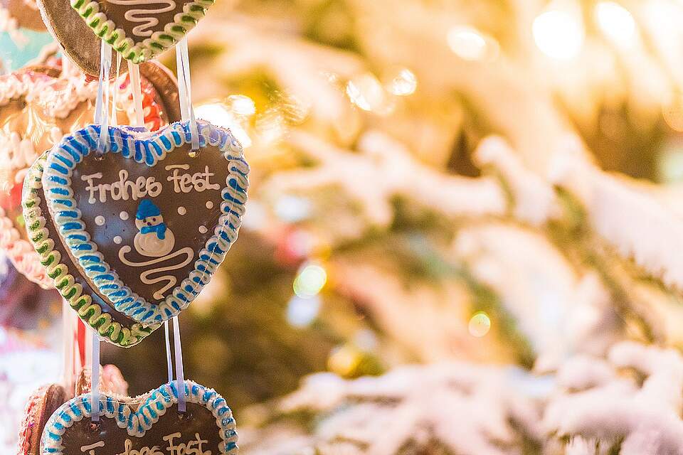 Weihnachtsmarkt in Forchheim 2024 aufgefädelte Lebkuchenherzen an einem weihnachtlich geschmücktem Stand mit der Aufschrift "Frohes Fest".