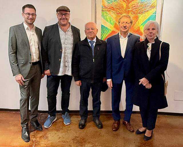 Forchheimer Delegation mit ehemaligen Bürgermeister Renzo Michelini, der die Städtepartnerschaft mitbegründet hatte. Im Hintergrund eine weiße Wand mit einem großen modernen Gemälde.