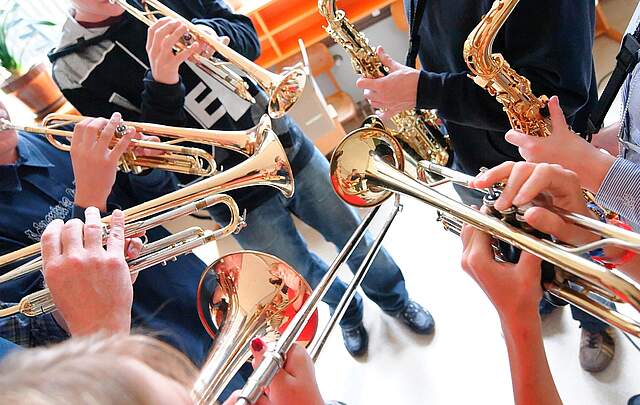 Kinder mit Blasinstrumenten die im Kreis stehen.