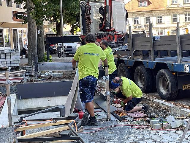 Drei Metallbauer bei der Errichtung eines Hochbaus am Tiefgarageneingang Süd des Forchheimer Paradeplatzes.