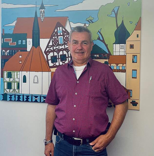 Bild von Ernst Messingschlager, vor Gemälde der Forchheimer Innenstadt