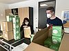 Frau und Mann verpacken Masken in Kartons