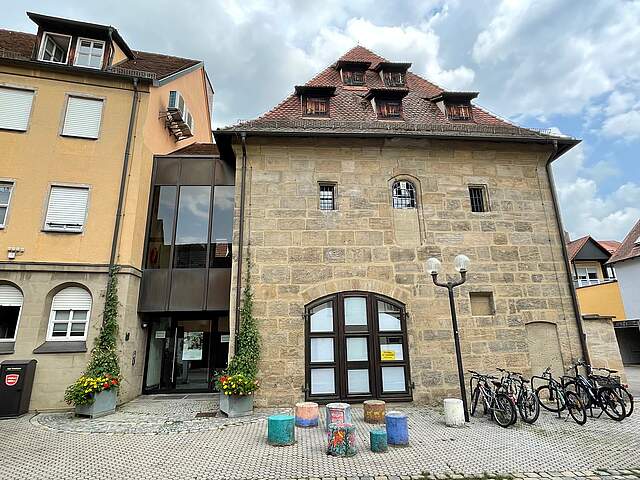 Frontalansicht der Fraunkscheune, die das Forchheimer Stadtarchiv beherbergt. Der massive Sandsteinbau erstreckt sich über zwei Vollgeschosse, sowie zwei weiteren Dachgeschossen.dsteinen
