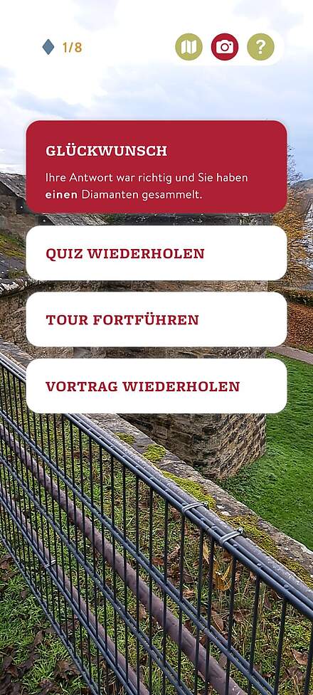 Screnshot aus der App Via Forte Screenshot einer Themen App. Im obersten roten Feld steht: Glückwunsch. Ihre Antwort war richtig und Sie haben einen Diamanten gesammelt. Darunter befinden sich drei weiße Felder. Wortlaut des ersten Feldes: Quiz wiederholen. Darunter der Wortlaut: Tour fortführen und letzt das Feld mit dem Wortlaut: Vortrag wiederholen.