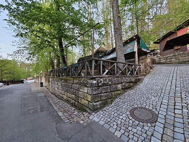 Rappenkeller Rappenkeller-Ansicht vom Hauptweg mit Sandsteinmauer und überdachten Sitzplätzen im Forchheimer Kellerwald.