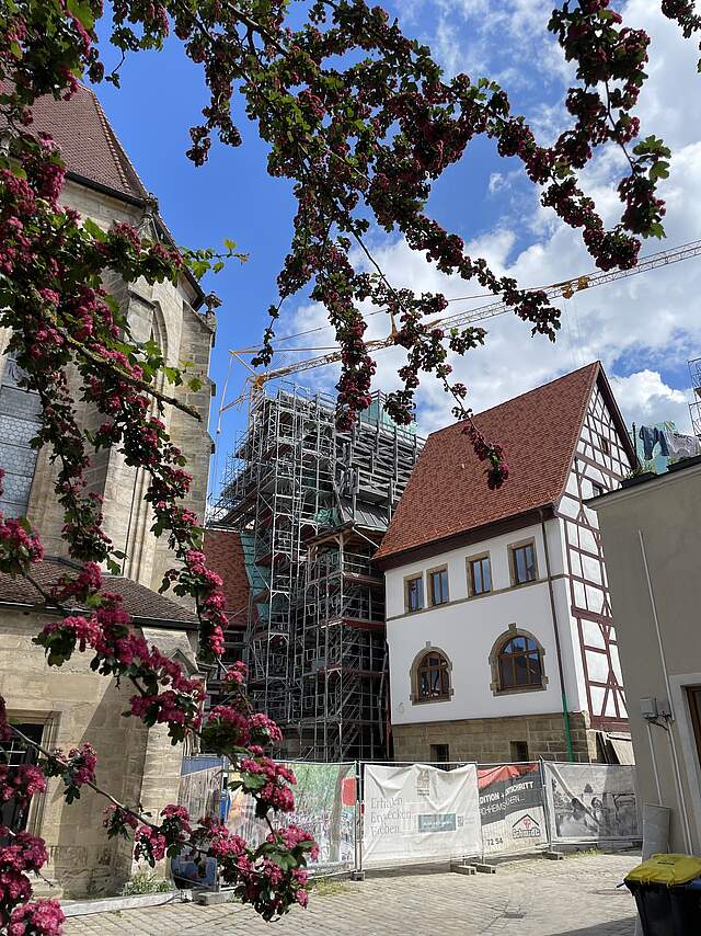 Rathaus Forchheim Außenansicht der Rückseite des historischen Rathauses in Forchheim mit der teilrestaurierten Fassade. Im Bild noch ein Teil der Kirche St. MArtin sowie einige blühende Äste des Rotdorns.