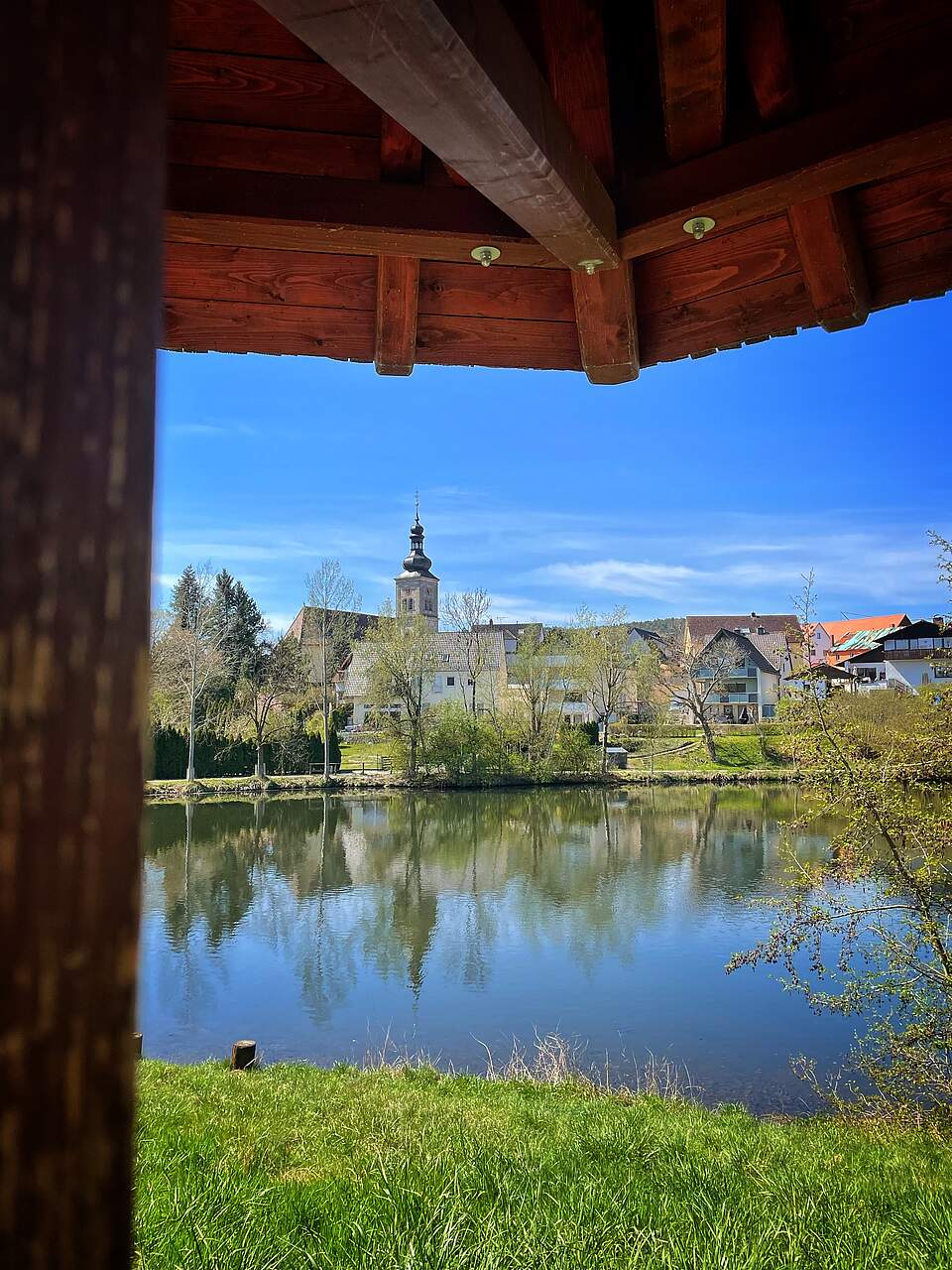 Blick vom Holzpavillion der Sportinsel über das Wasser nach Burk.