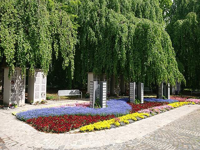 Bild vom Friedhof mit bepflanztem Beet und Urnenstelen