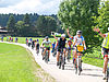 Eine Gruppe Radfahrerinnen und Radfahrer fahren durch eine Landschaft.