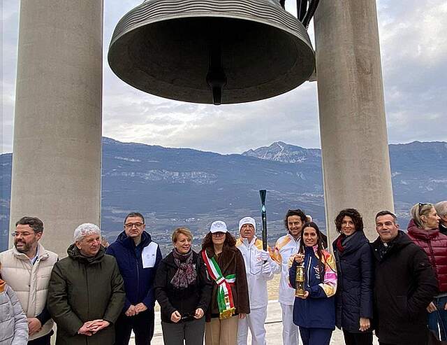 Mehrere Personen stehen vor der Friedensglocke in Rovereto