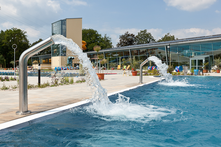 Außenbecken mit Wassersprudelanlage Zwei Außenwasserwasserfallanlagen an einem Außenbecken in einem Freizeitbad.