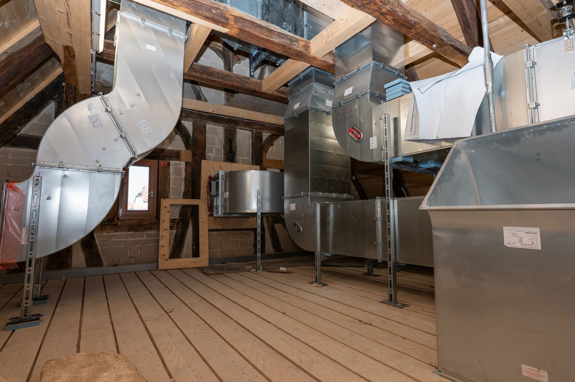 Installation der modernen Lüftungsanlage Eine moderne Lüftungsanlage wurde im Dachgeschoss des historischen Rathauses installiert. Fachwerk ziert die Wände des Gebäudes.
